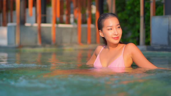 Young asian woman enjoy around outdoor swimming pool for leisure