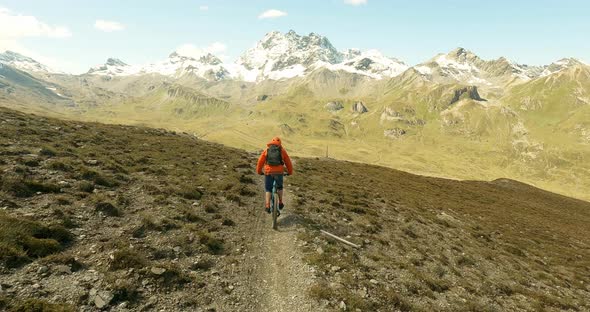 Single trail mountain bike fun in the austrian alps with beautiful snow covert mountains in the back