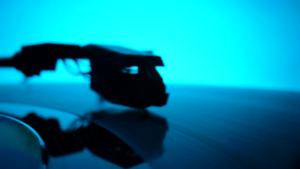 Music Retro Turntable with Spinning Vinyl Record Against Backdrop of Blue Lights