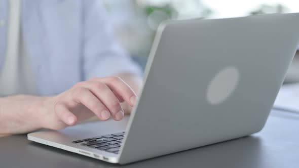 Close Up of Hands of Man in Glasses Typing on Laptop