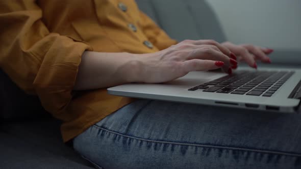 Attractive Young Woman Enjoying What She is Doing As She Works on Her Computer in Her Apartment