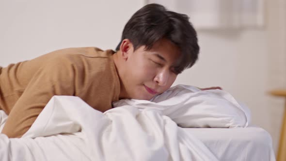 Handsome Attractive Asian man sleep and sweet dream laying down on bed in cozy bedroom