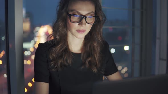 Closeup Portrait of Business Woman on Night City Background. the Girl Works Late in the Office