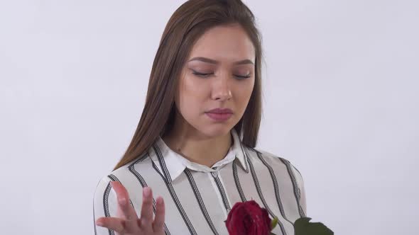 Close Up Portrait Sad Young Beautiful Woman Pulling Up Petals From the Red Rose