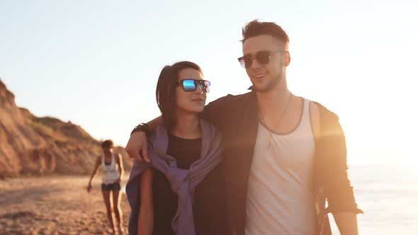 Friends Smiling Laughing Speaking Walking at Seaside at Sunrise