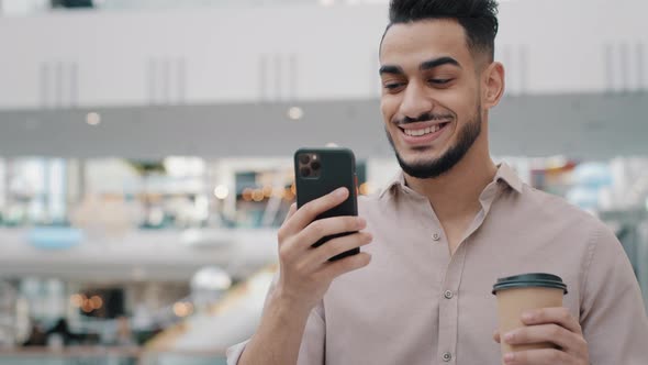 Closeup Businessman Walking in Mall Holding Mobile Phone Hispanic Guy Smiling Drinking Coffee
