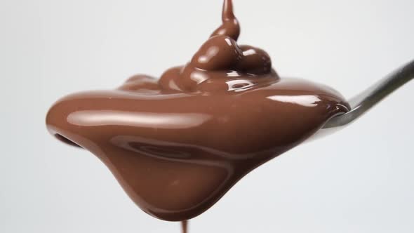 Splash of chocolate cream filling a teaspoon in slow motion
