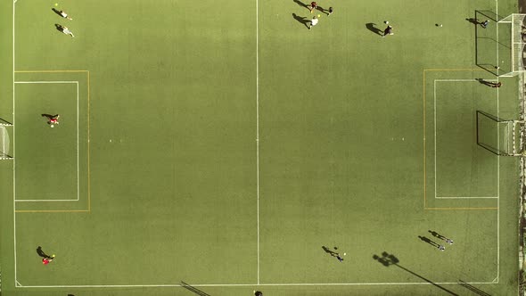 Aerial view of people training football in a beautiful football camp.