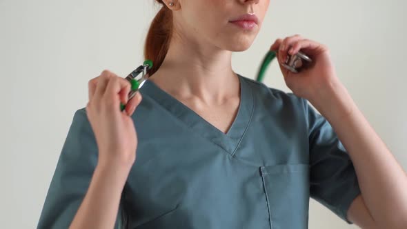 Closeup Cropped Shot of Unrecognizable Female Practitioner in Green Medical Uniform Putting