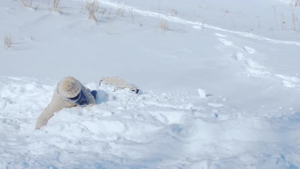 Woman Riding Down a Steep Hill on a Sledge