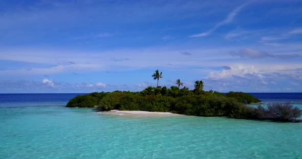 Tropical above island view of a paradise sunny white sand beach and aqua blue water background in 4K