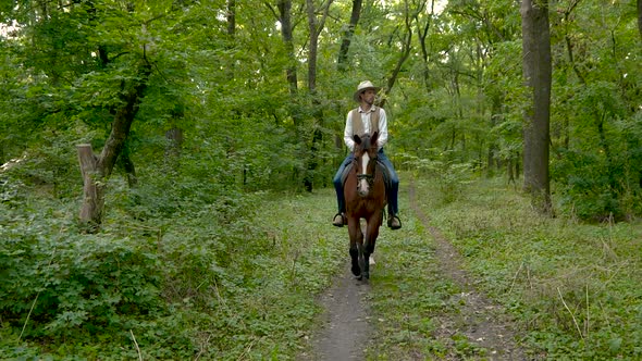 Young Cowboy on Horseback in the Forest