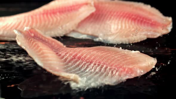 Fish Fillets Fall on the Table with Splashes of Water