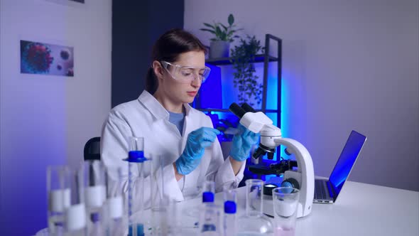 Virologist is Examining Sample Under Microscope Working in Science Laboratory