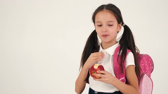 Beautiful Schoolgirl Eating Apple Isolated in Studio