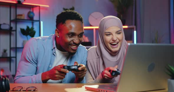 Black-Skinned Guy Celebrating Victory in Video Game Over His Arabic Female Partner