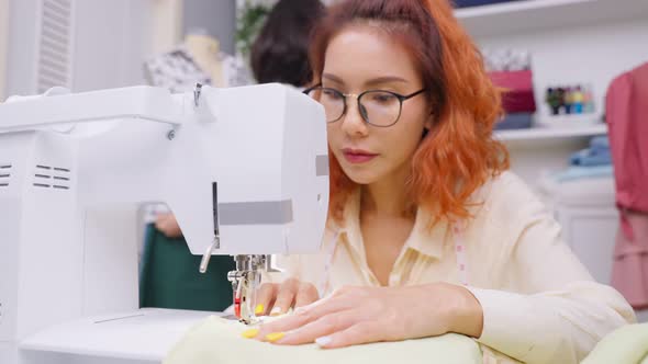 Asian beautiful tailor woman working on clothes in tailoring atelier.