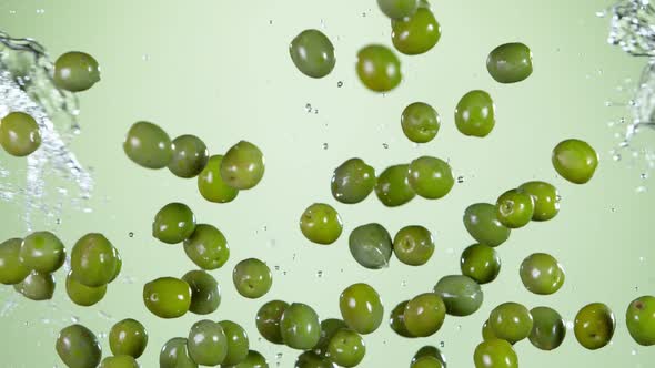 Super Slow Motion Shot of Flying Olives and Water Side Splash at 1000 Fps