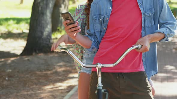 Couple using phone while riding bicycle 