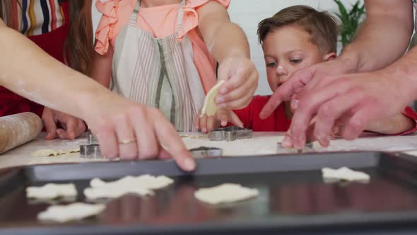 Hands of happy caucasian family baking together, preparing cookies in kitchen