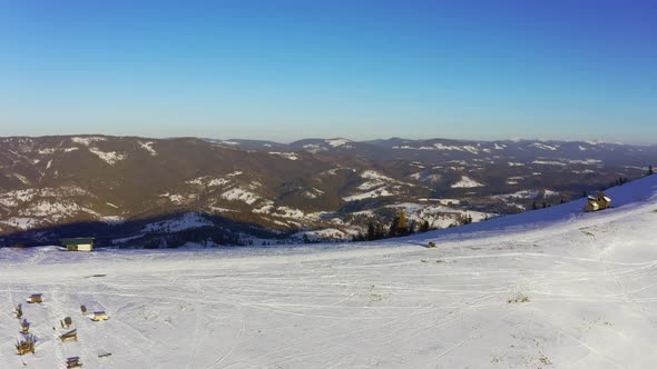 Old Ski Station on a Snowy Mountain Slope with a Lot of People on Skis and Snowboards