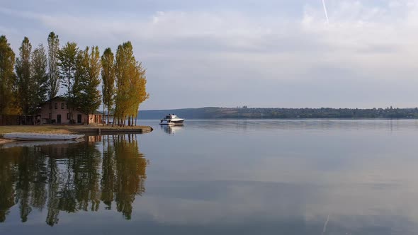 Scenic view with a house on the riverbank of Nistru river and a yacht floating