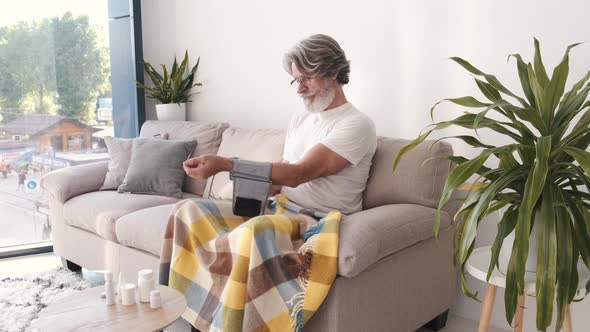 Old Man Measuring Blood Pressure at Home