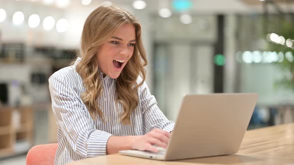 Excited Businesswoman Celebrating Success on Laptop in Office 