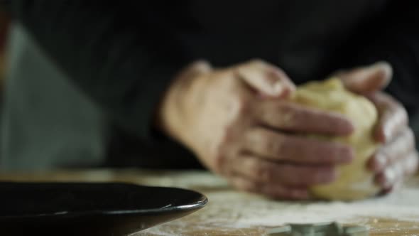 Woman in kitchen kneading dough