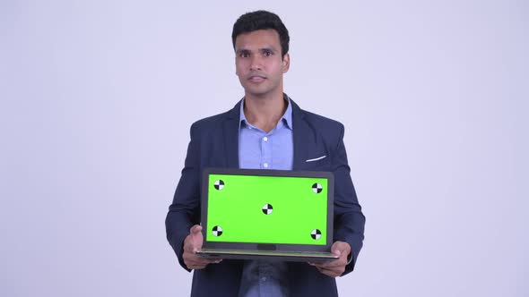 Happy Young Indian Businessman Showing Laptop and Looking Surprised