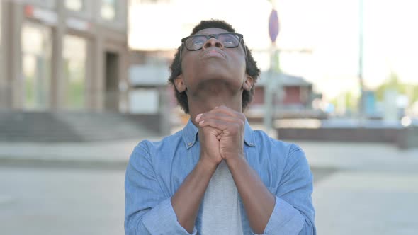 Young African Man Praying to God Outdoor