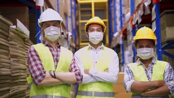 Group of interracial worker people put on protective face mask in warehouse factory due to Covid19.