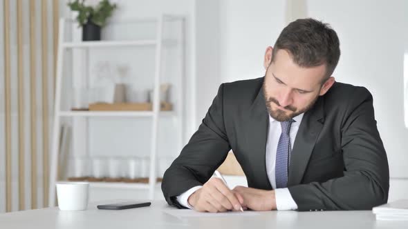 Businessman Writting Documents in Office