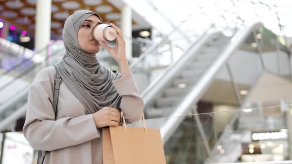 Young Muslim Woman Drinking Coffee in Mall