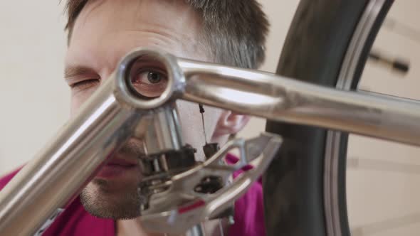 Man Looks Into Hole in Frame of Bicycle