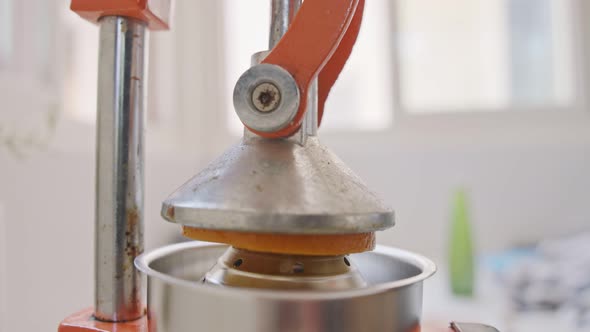 Super slow motion of fresh orange juice squeezed using a manual squeezer