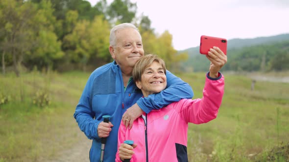 Happy Senior Couple Having Fun Taking a Selfie Hiking in the Woods Healthy Elderly and Technology
