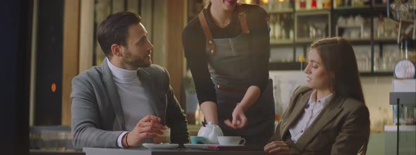 Young female waiter bringing plate