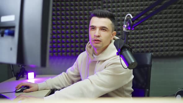 A Pensive Radio DJ is Preparing to Conduct a Live Broadcast in a Radio Studio