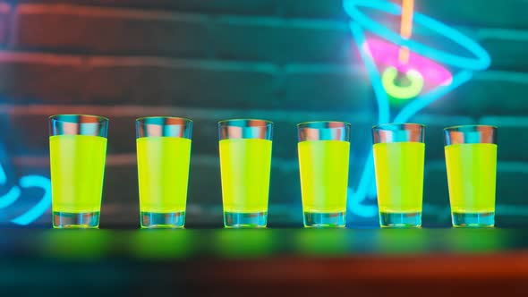 Green shots on the bar. Colourful alcoholic drinks on the table in a nightclub.