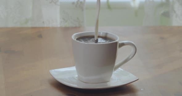 Milk is Poured Into a Cup of Freshly Brewed Coffee