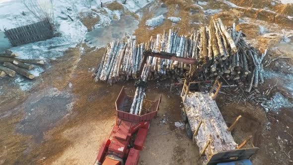 A Truck With Manipulator Loads Firewood Into A Shredder For Firewood