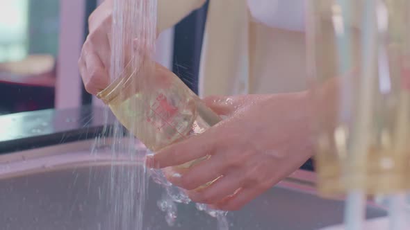 Mother's Hand Washing The Bottle