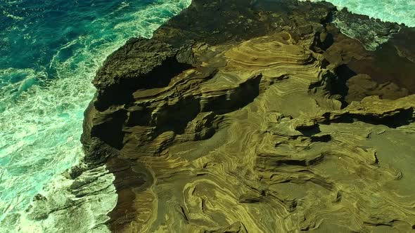 Overhead view of waves splashing over volcanic rock formation on Oahu