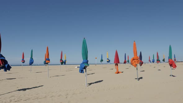 DEAUVILLE, FRANCE - SEPTEMBER 2016 Slow pan of famous film festival city beach with colorful parasol