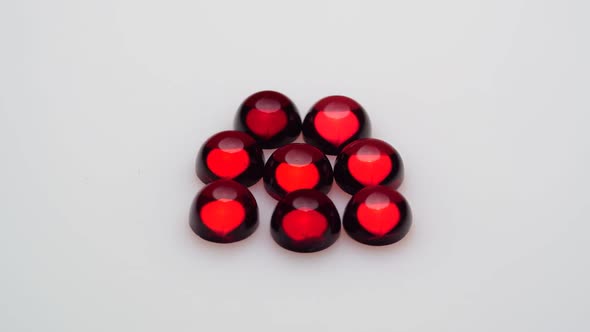 Natural Red Garnet Gemstone on the White Background on the Turning Table