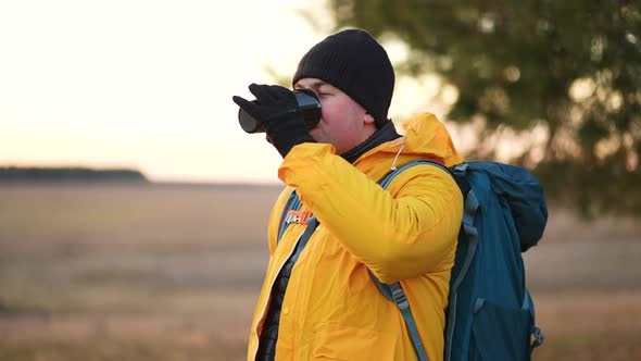 Hiker Young Tourist Enjoying Nature Drinking Hot Tea at Sunset