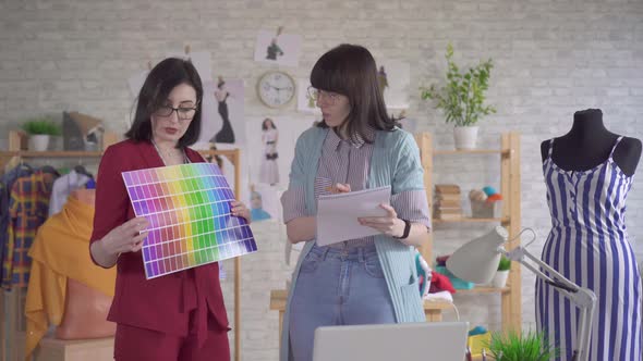 Two Young Fashion Designers at Work in the Studio Choose a Color in the Palette