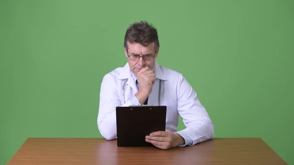 Mature Handsome Man Doctor Against Green Background