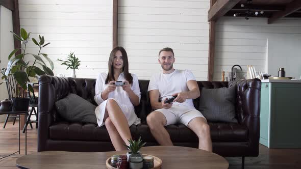 A guy with a girl playing video games in a modern apartment